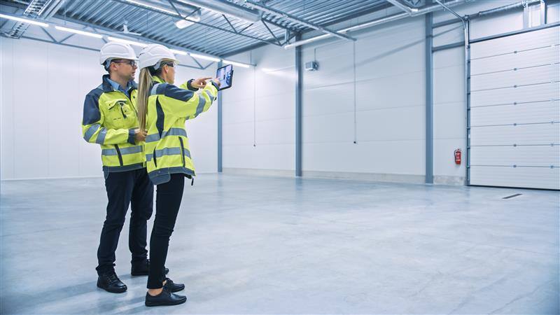 Warehouse operatives reviewing warehouse space.